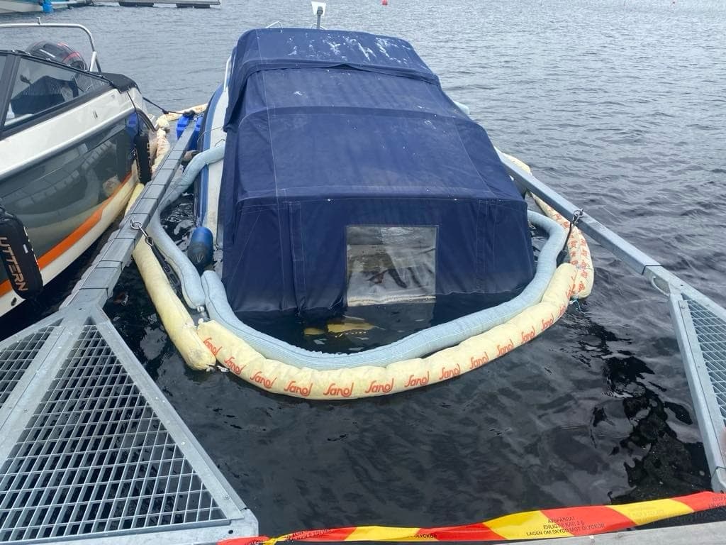 Boom deployed around a boat in a marina